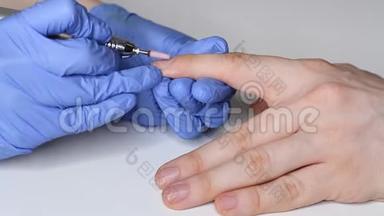关心男人`指甲。 穿着蓝色手套的美容师给男人修指甲。 男人`美的概念